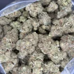 Close-up bulk shot of Death Bubba buds highlighting their frosty trichomes and vibrant coloration.