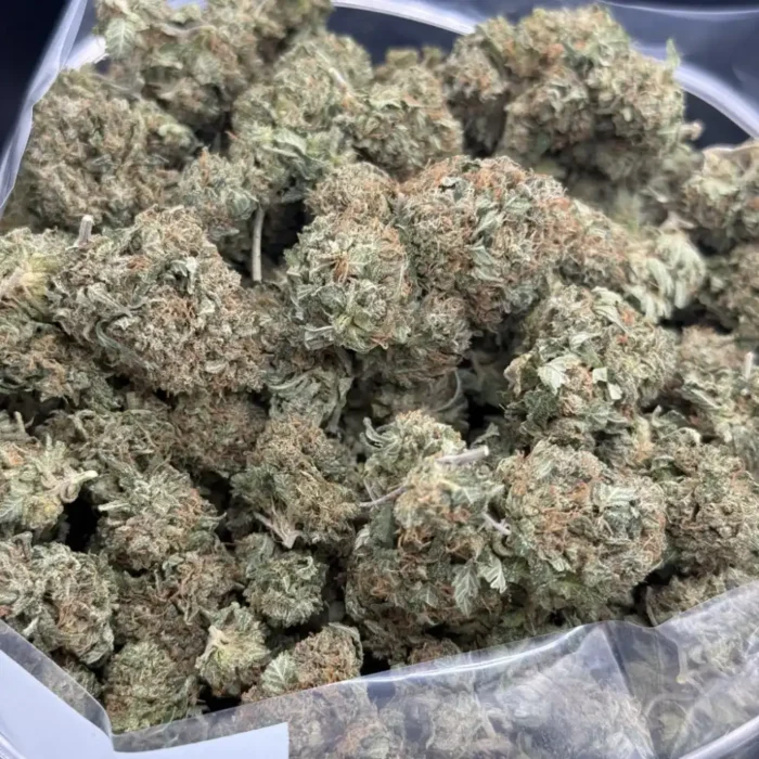 Close-up bulk shot of Pink Kush AA buds showing frosty trichomes and pink pistils.