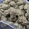 Bulk Pink God cannabis buds with pink pistils, purple hues, and frosty trichomes.